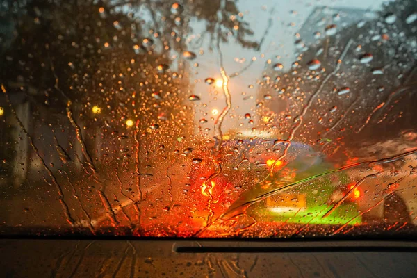 Regentropfen und Straßenlicht-Bokeh auf Windschild — Stockfoto