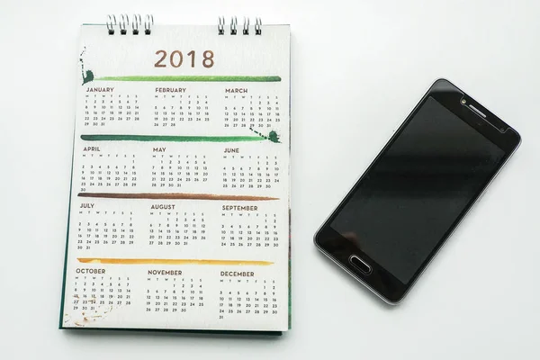 isolated creative design 2018 calendar with smartphone for planing appointment