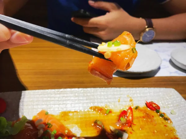 Close Van Mensen Met Stokjes Voor Eten Kruidig Zalm Salade — Stockfoto