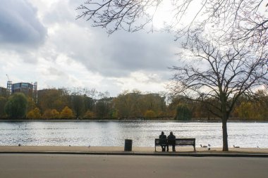 yaşlı çift sonbaharda parkta bankta oturmak