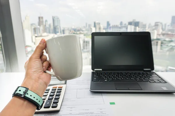 people with coffee mug during tea break at office desk