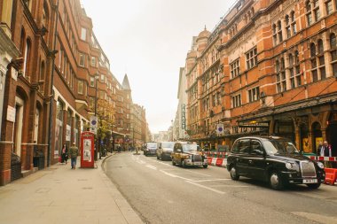 Londra / İngiltere'de - 22 Kasım 2017: siyah taksi ile yol boyunca'nde Günbatımı bina vintage