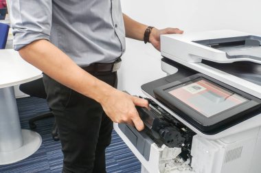 Gri gömlekli belgeleri yazdırmak için office çok işlevli yazıcı mürekkep kartuşu koymak işadamı kapatmak