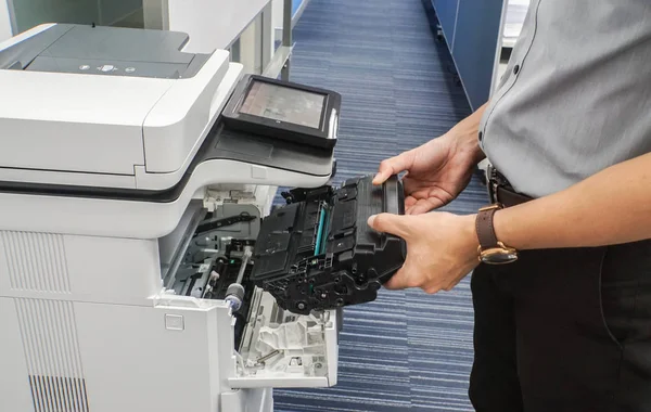 close up businessman hold toner cartridge to put into printer feed