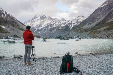 turist adam ceket ile Mount Cook fotoğraf Dslr fotoğraf makinesi tripod ile tarafından alır