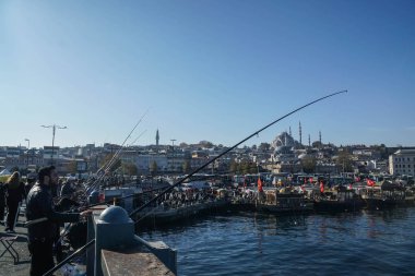 İstanbul. Türkiye - 10 Aralık 2019: insanlar sabah Yeni Cami ile Karadeniz 'deki Galata Köprüsü' nde balık tutuyorlar