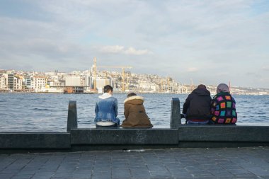 Seçici odaklanma aşığı ve yaşlı çiftler tatilde Karadeniz 'de bankta otururlar.