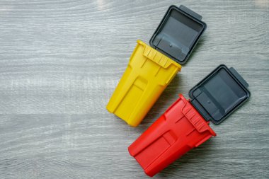 Kuru ve tehlikeli çevre çöpleri için sarı ve kırmızı çöp kutularının üst görünümü