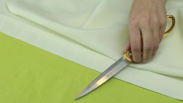 Alfaiate coloca tesouras e cortador de alfaiate na peça de tecido bege . — Vídeo de Stock