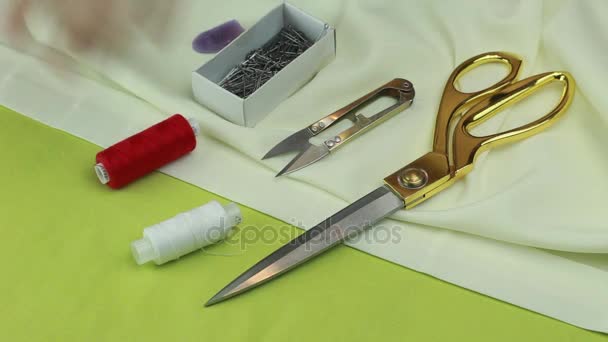 Tailor Removes Sewing Utensils With a Piece of Fabric - a Pair of Scissors, Tailor's Cutter, Thread, Dressmaker Pins, Chalk and a Needle and Thread. — Stock Video