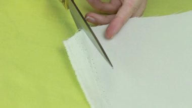 Makas kesim bej kumaş kenarına terzi. Kumaş kenarına virajlı.