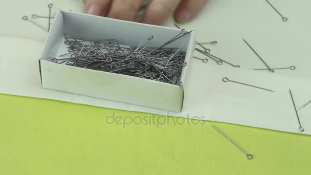 Tailor pone alfileres de modista en la caja, que se dispersaron en una tela beige 2 — Vídeo de stock
