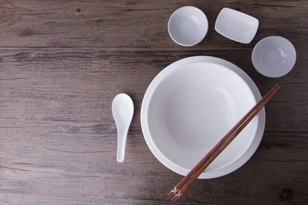 Empty white bowl , sauce bowls , spoon and chopsticks