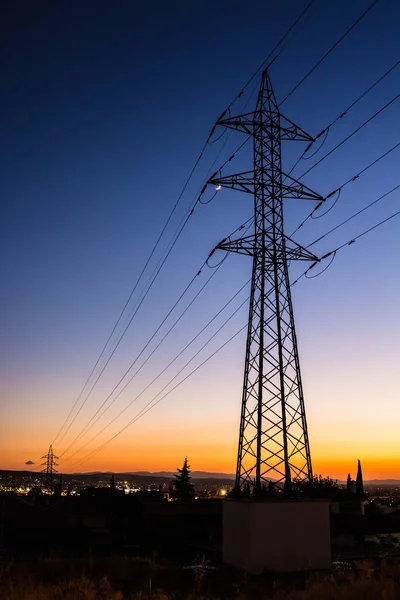 Tour d'électricité près d'une zone urbaine contre un ciel dégagé — Photo