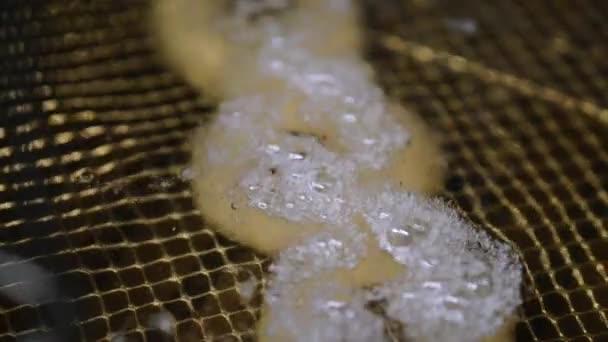 Uienringen koken in hete bubbly olie in een friteuse — Stockvideo