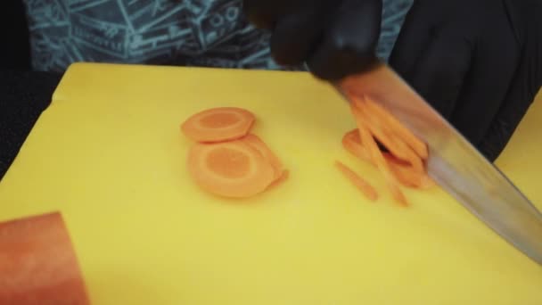 Повар режет морковь — стоковое видео
