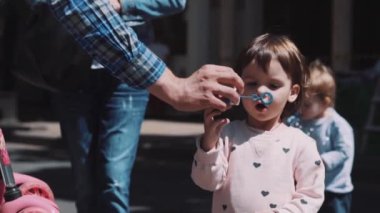 little girl blows soap bubbles