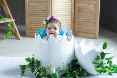 Bahar geldi. Çiçekler. Süslemeleri için fotoğraf stüdyosu. Küçük kız. Paskalya yumurtası. Ahşap arka plan. Güneş ışınları. Kabarık elbise.