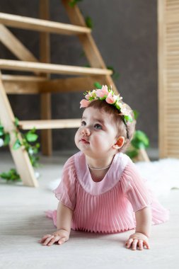 Bahar. Çiçekler. Fotoğraf stüdyosu için süsler. Küçük kız. Güneş ışınları. Kabarık elbise. Çiçek çelenk. 