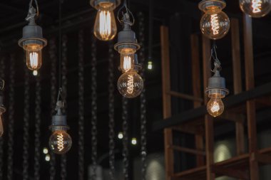 Avize lamba ışığında içinde üzerinde Işık Ampüller Lambalar koyu arka plan üzerinde tavandan asılı aydınlatma. Kahve Dükkanı dekorasyonu .