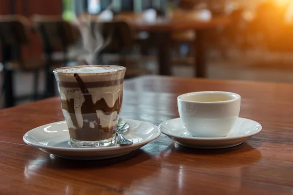 Hot milk latte art coffee on wooden table .