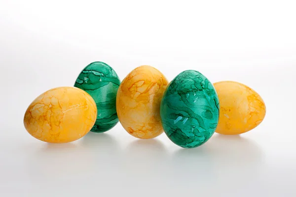 Beyaz arka planda beş renkli yumurta.