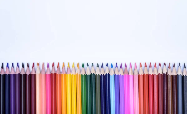 Lápices de colores acostados en una mesa en una fila —  Fotos de Stock