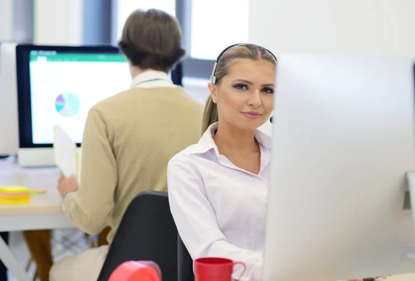 Молода красива жінка працює на комп'ютері в офісі — стокове фото