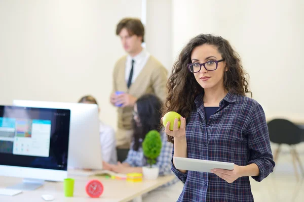 Fiatal nő eszik almát, iroda — Stock Fotó