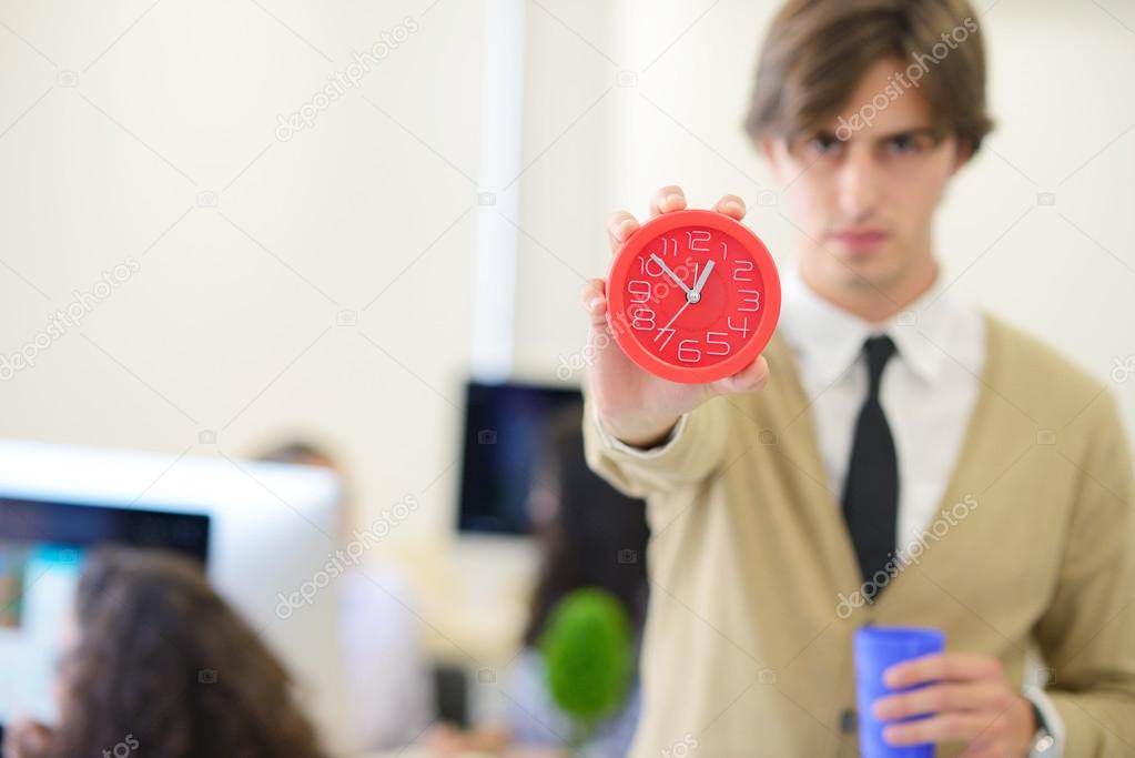 young angry businessman pointing his watch 