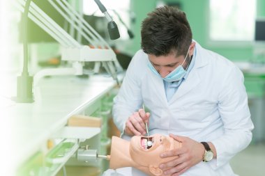 Bebek üzerinde pratik diş öğrenci. 