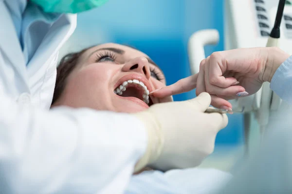 Tandläkaren undersöka patientens tänder med en mun spegel. — Stockfoto