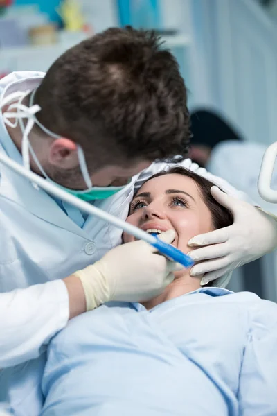 Dentista examinando os dentes do paciente com um espelho bucal . — Fotografia de Stock