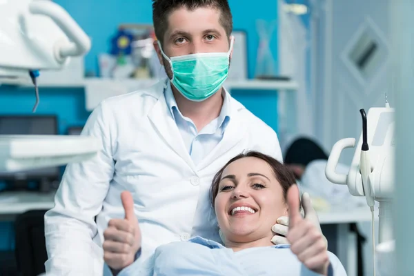 Dentista examinando os dentes do paciente com um espelho bucal . — Fotografia de Stock