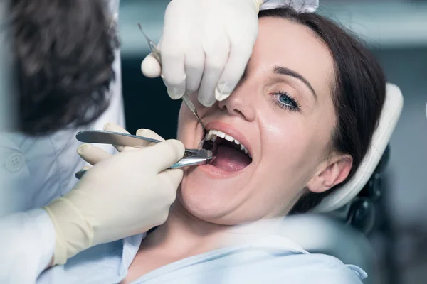 Dentista examinando os dentes do paciente com um espelho bucal . — Fotografia de Stock