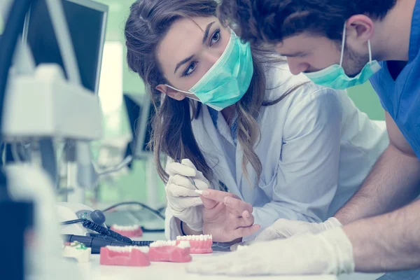 Estudiantes dentales mientras trabajan en la dentadura postiza —  Fotos de Stock