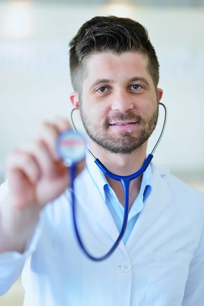 Médico varón mostrando estetoscopio —  Fotos de Stock