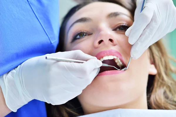 Dentista femenino examinando los dientes del paciente —  Fotos de Stock