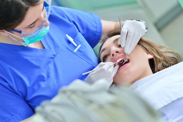 Kvinnliga tandläkare undersöker patientens tänder — Stockfoto