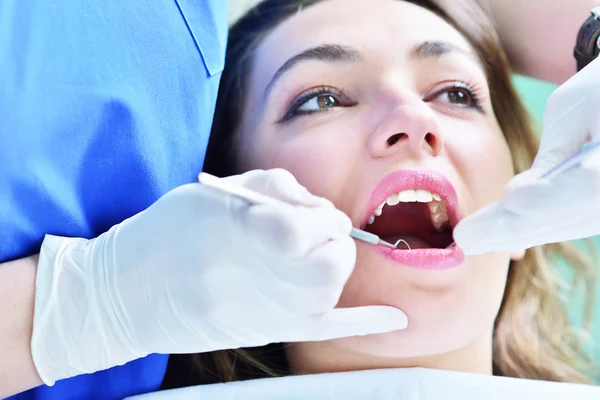 Dentiste féminine examinant les dents du patient — Photo