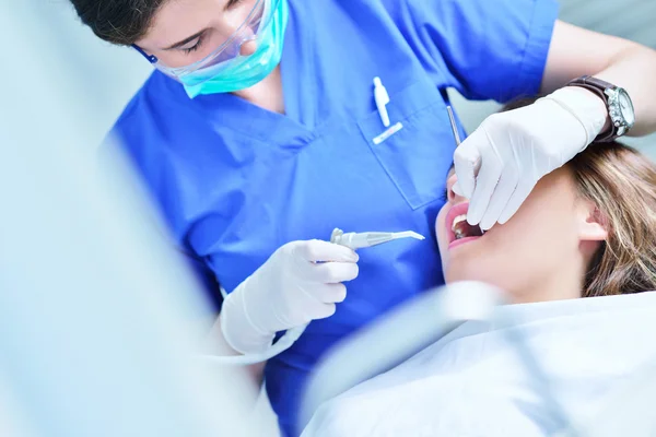 Dentiste féminine examinant les dents du patient — Photo