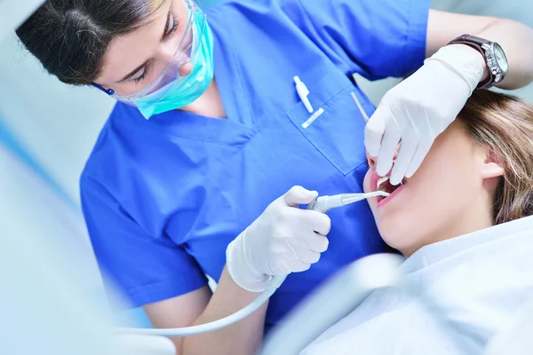 Dentiste féminine examinant les dents du patient — Photo