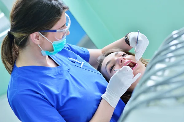 Kvinnliga tandläkare undersöker patientens tänder — Stockfoto