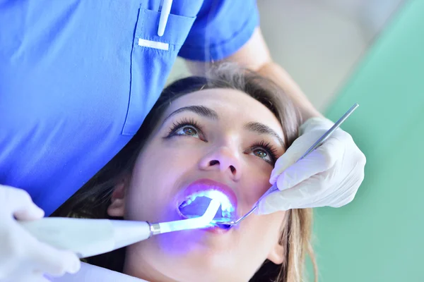Dentiste féminine examinant les dents du patient — Photo