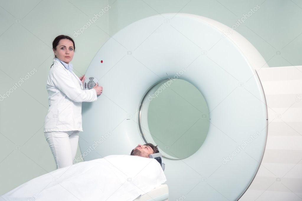 Nurse preparing patient for CT scan test in hospital room