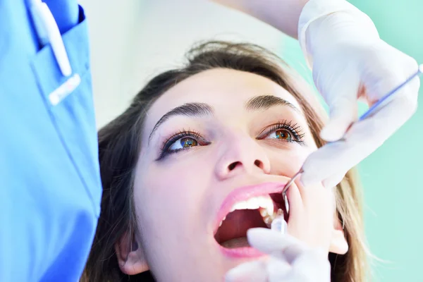 Dentiste féminine examinant les dents du patient — Photo
