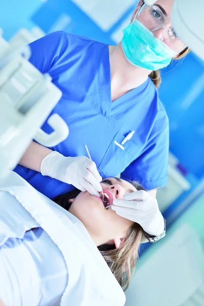 Dentiste féminine examinant les dents du patient — Photo