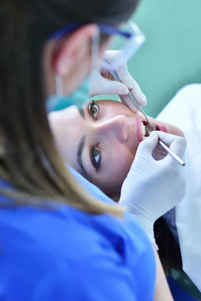 female Dentist examining Patient teeth