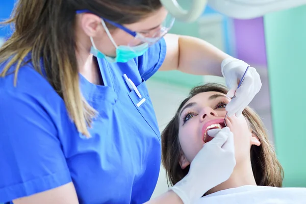 Dentiste féminine examinant les dents du patient — Photo