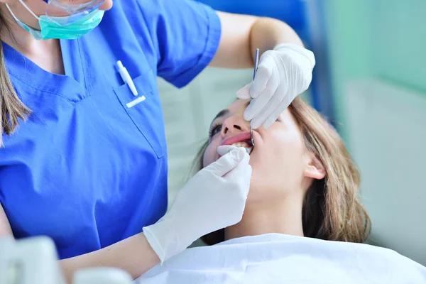 Kvinnliga tandläkare undersöker patientens tänder — Stockfoto